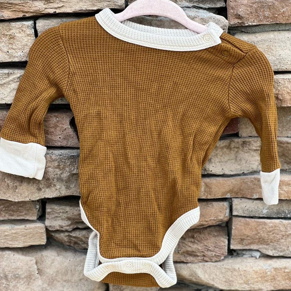 Goumi, it has buttons on the for easy access for diaper changes